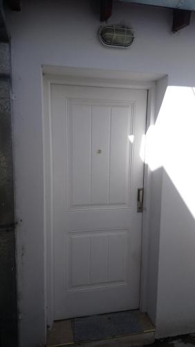 a white garage door with a light on top of it at Departamento Ananda in General Roca