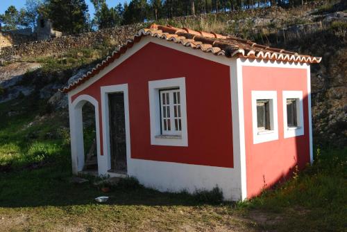 a small red and white house on a hill at Prédio na Amêndoa in Amêndoa