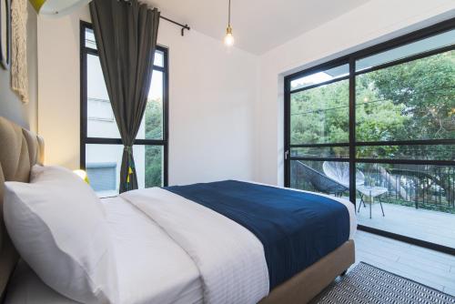 sypialnia z łóżkiem i dużym oknem w obiekcie Mr. Brooklyn - By TLV2GO w Tel Awiwie