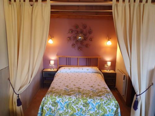 a bedroom with a bed with two lamps and curtains at Aptos. Rurales Los Falares de la Abuela Berta (Adults Only) in Nieda