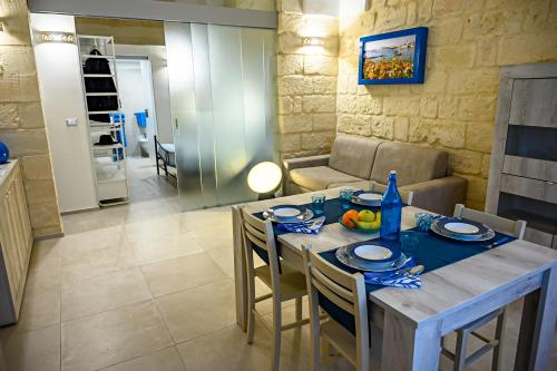 a kitchen and dining room with a table and chairs at VENTINOVE Apartments in Otranto