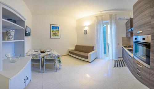 a kitchen and living room with a table and a couch at VENTINOVE Apartments in Otranto