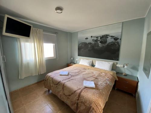a bedroom with a large bed with a tv on the wall at Casa Candelaria in Candelaria