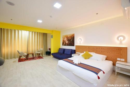 ein Schlafzimmer mit einem großen Bett und einem blauen Sofa in der Unterkunft LAMITA in Madschdal Schams