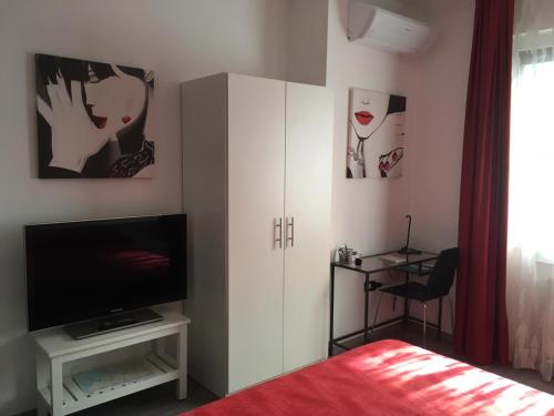 a bedroom with a bed and a tv and a cabinet at Matt5, il tuo angolino triestino in Trieste