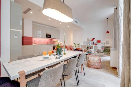 une salle à manger et une cuisine avec une grande table et des chaises dans l'établissement Sweett - Turenne, à Paris