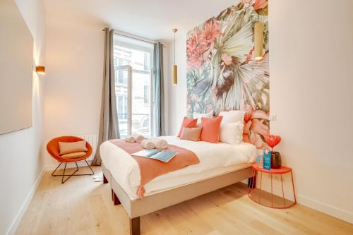una camera da letto con un letto e un dipinto sul muro di Sweet Inn - Turenne a Parigi