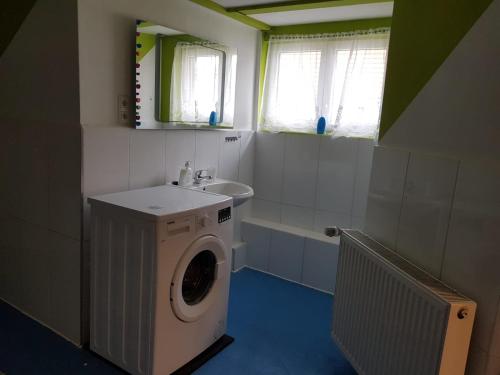 a bathroom with a washing machine and a sink at LMI Haus & Urlaub Monteurwohnungen 2 in Münsingen