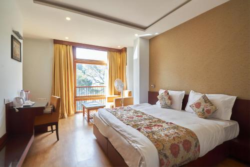 a hotel room with a large bed and a window at The Golden Crest in Gangtok