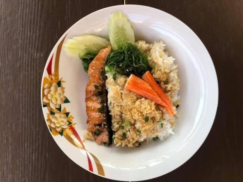 a plate of food with rice and carrots and vegetables at นงนุช โฮมสเตย์ & รีสอร์ท บุรีรัมย์ in Buriram