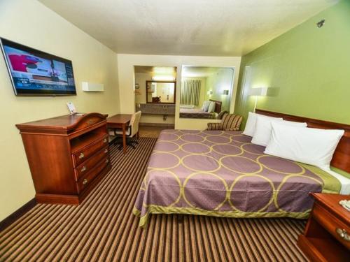 塔克的住宿－大師塔克旅館，酒店客房设有一张大床和一张书桌。