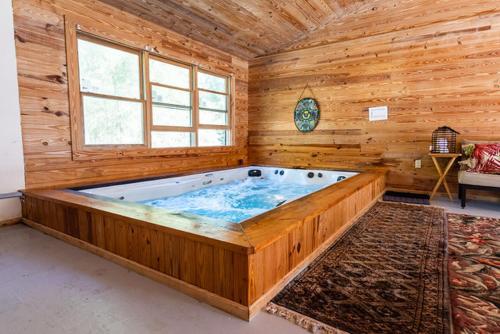 a large soaking tub in a wooden room at PRIVATE Log Cabin with Indoor pool sauna and gym YOU RENT IT ALL NO ONE ELSE in McAlpin