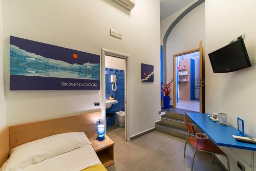 a room with a bed and a desk and a tv at Affittacamere del Golfo e delle 5 Terre in La Spezia