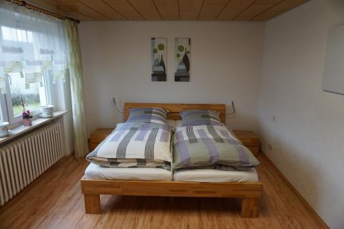 a bedroom with a bed with two pillows and a window at Ferienwohnung in der Rhön in Willmars