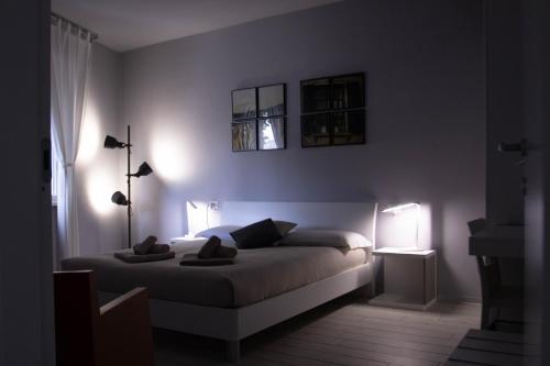 a bedroom with a bed and two lights on the wall at Le3stanze in Borgomanero