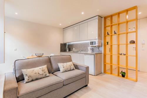 a living room with a couch and a kitchen at Lemago Porto Apartments - São Bento in Porto