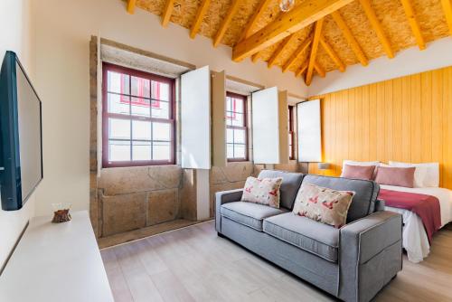 a living room with a couch and a bed at Lemago Porto Apartments - São Bento in Porto