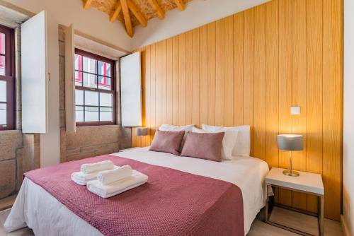 1 dormitorio con 1 cama grande y 2 toallas. en Lemago Porto Apartments - São Bento en Oporto