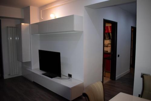 sala de estar con TV en una pared blanca en apartament valcea en Râmnicu Vâlcea
