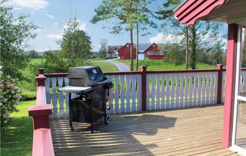 a barbecue grill on a deck with a fence at Amazing Home In Öxabäck in Öxabäck