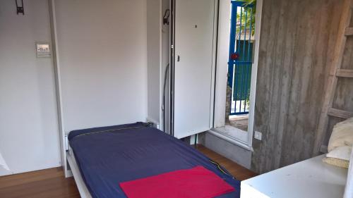 - un lit dans une chambre avec une porte ouverte dans l'établissement Under the Acropolis, tiny room, big terrace, à Athènes