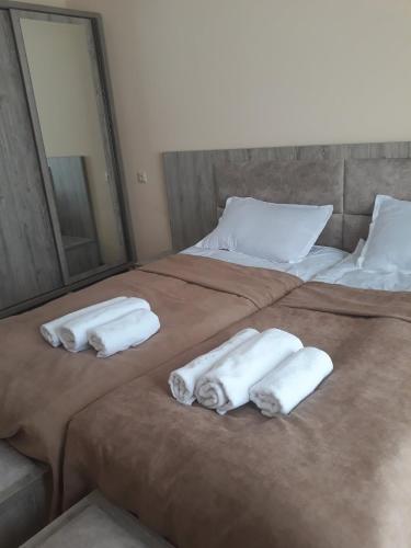 two beds with folded towels on them in a bedroom at Hotel Ramaz Paliani in Mestia