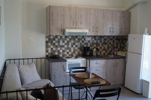 una piccola cucina con tavolo e frigorifero di Sea Side Apartment a Palaia Fokaia