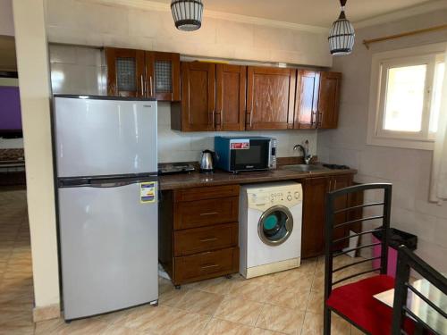 a kitchen with a refrigerator and a washing machine at Penthouse Three-Bedroom Villa in Porto Sokhna Family only in Ain Sokhna