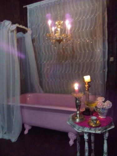 a bathroom with a pink tub and a table with candles at La Petite France in Nova Petrópolis