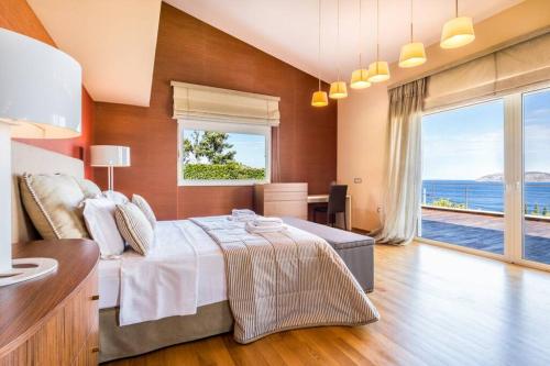 Schlafzimmer mit einem großen Bett und Meerblick in der Unterkunft Amazing 5 bedroom Villa with Swimming Pool in Athen