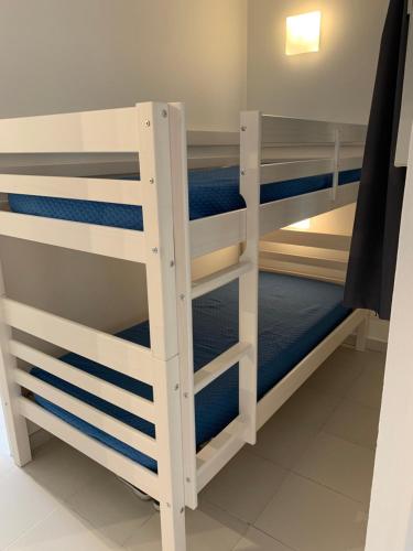 Litera con literas blancas y azules en Appartement agréable en bord de mer, en Villefranche-sur-Mer
