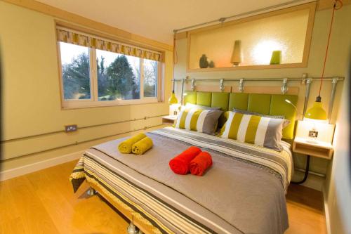 a bedroom with a bed with three pillows on it at Claron Lodge in West Wittering