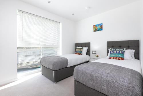 Un pat sau paturi într-o cameră la Skyvillion - Olympic View London Stratford Apartment