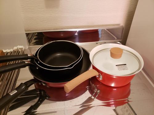 a pan and a pot on a stove top at おもてなしハウスさいたま in Saitama