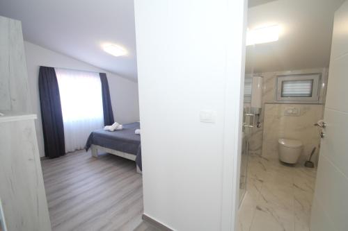 a bedroom with a bed and a bathroom at Luxury apartment Navi in Podstrana