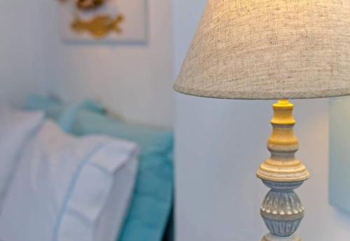 a close up of a lamp with a lampshade next to a couch at Aspro Mple in Astypalaia