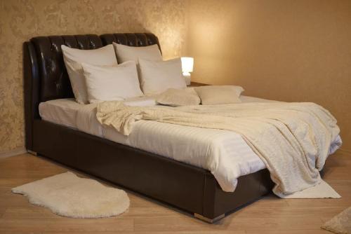 a large bed with a black frame and white pillows at PaulMarie Apartments on Prs. Lenina, 51 in Gomel