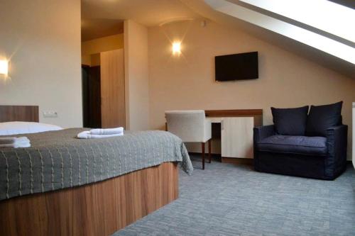 ein Hotelzimmer mit einem Bett, einem Stuhl und einem Schreibtisch in der Unterkunft Penzion Lipa in Cífer