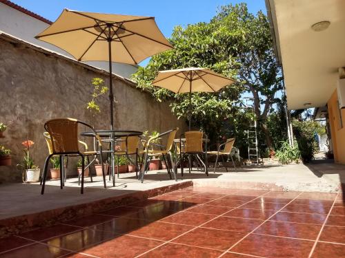 a patio with chairs and tables and umbrellas at Piezas con Baño Privado Economicas in La Serena