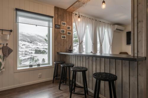 un bar con taburetes en una habitación con ventana en SAGI 4 PRIVATE APARTMENT, en Hafslo