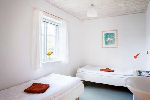 two beds in a room with a sink and a window at STF Brantevik Råkulle Hostel in Brantevik