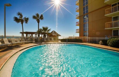 a swimming pool in front of a building with palm trees at Just Updated - Beachfront Ocean view, 19th Floor in Destin