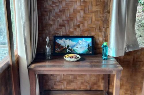einen Tisch mit einem Bild und einer Schüssel darauf in der Unterkunft SeaGate Bungalows in Sabang