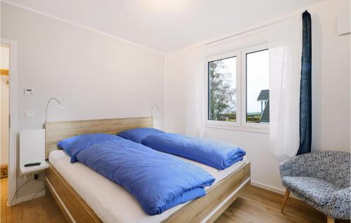 a bedroom with a bed with blue pillows on it at Cozy Apartment In Rechlin With Lake View in Rechlin