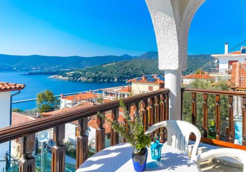 a balcony with a table and chairs and a view of the water at Kritikos Apartments in Pyrgadikia