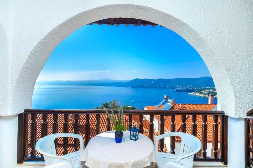 a balcony with a table and chairs and a view of the water at Kritikos Apartments in Pyrgadikia