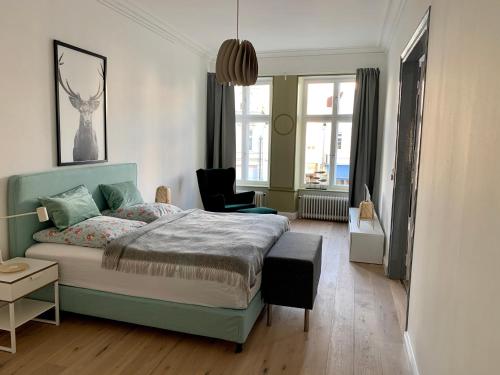 a bedroom with a bed and a chair and windows at Royal Residence in Lübeck