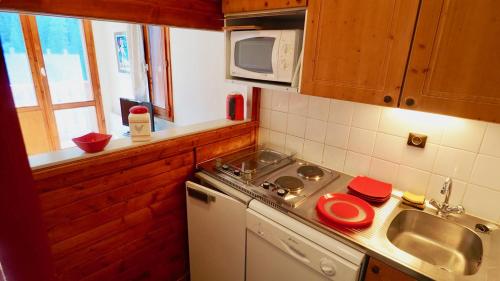 una pequeña cocina con fregadero y microondas en station valfréjus chavière, en Modane
