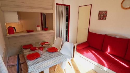 sala de estar con mesa y sofá rojo en station valfréjus chavière, en Modane