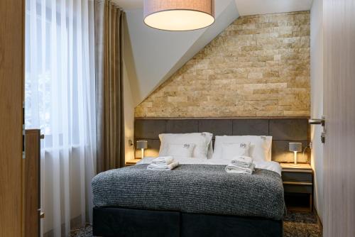 a bedroom with a bed and a brick wall at Apartamenty Pulower z klimatyzacją - Dream Apart in Szczyrk